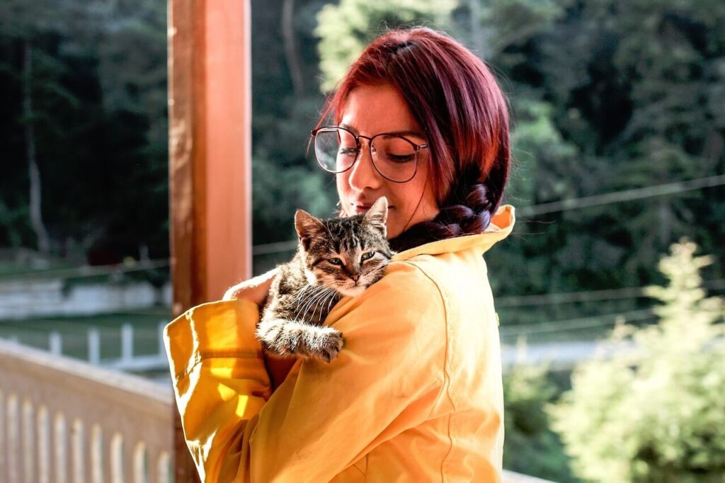 Woman hugging a tabby-looking cat - Conclusion of the Ultimate Cat Care Guide